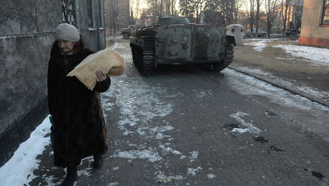 Пожилая женщина с хлебными лепешками после раздачи гуманитарной помощи жителям Дебальцево, которую привезли ополченцы