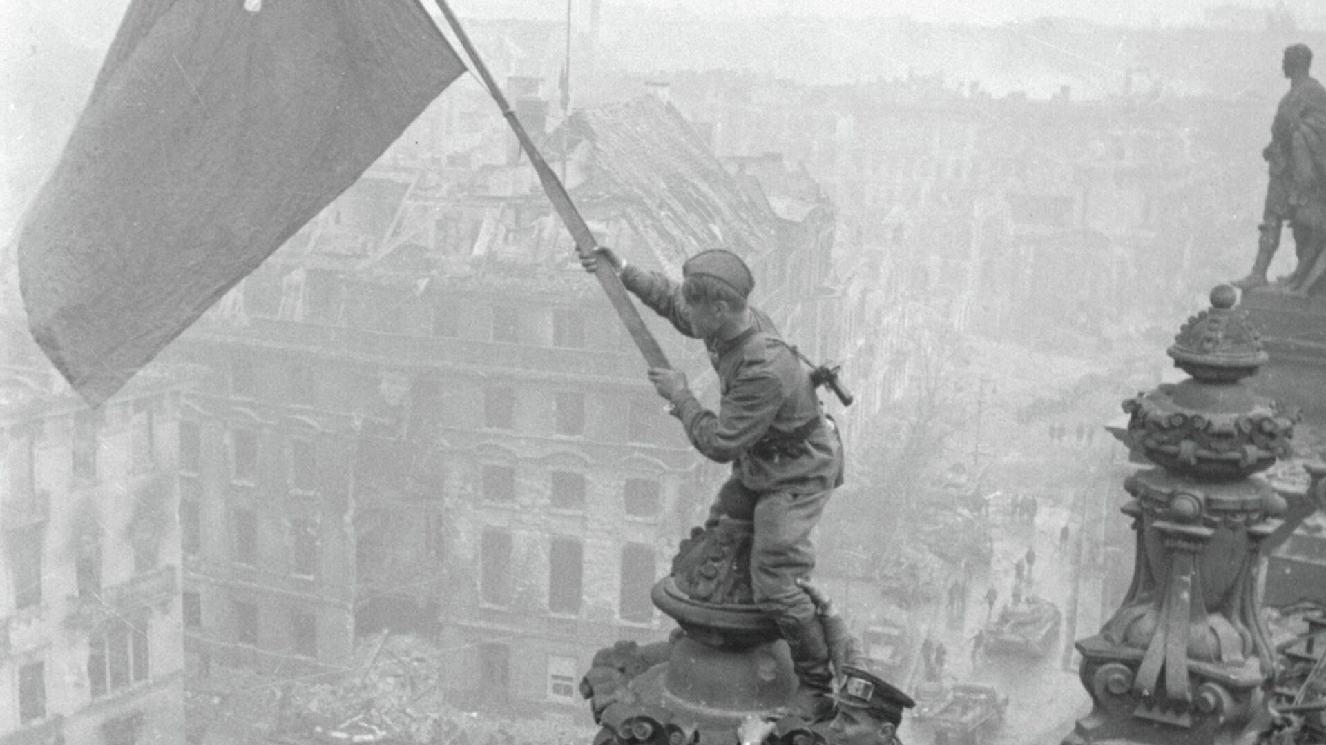 Боец водружает знамя Победы на крыше здания в Берлине - РИА Новости, 1920, 28.08.2025