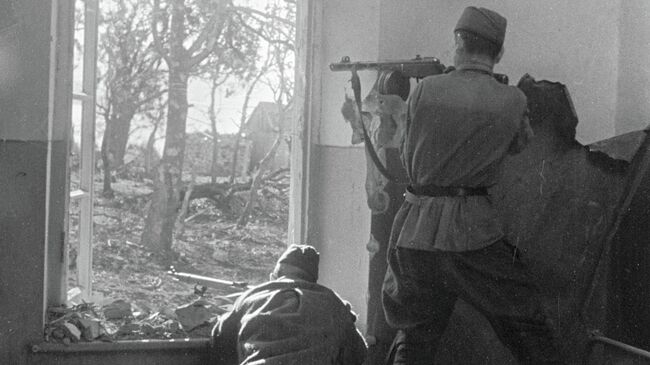 Бойцы ведут огонь по противнику из проема окна на окраине Новороссийска Бойцы ведут огонь по противнику из проема окна на окраине Новороссийска