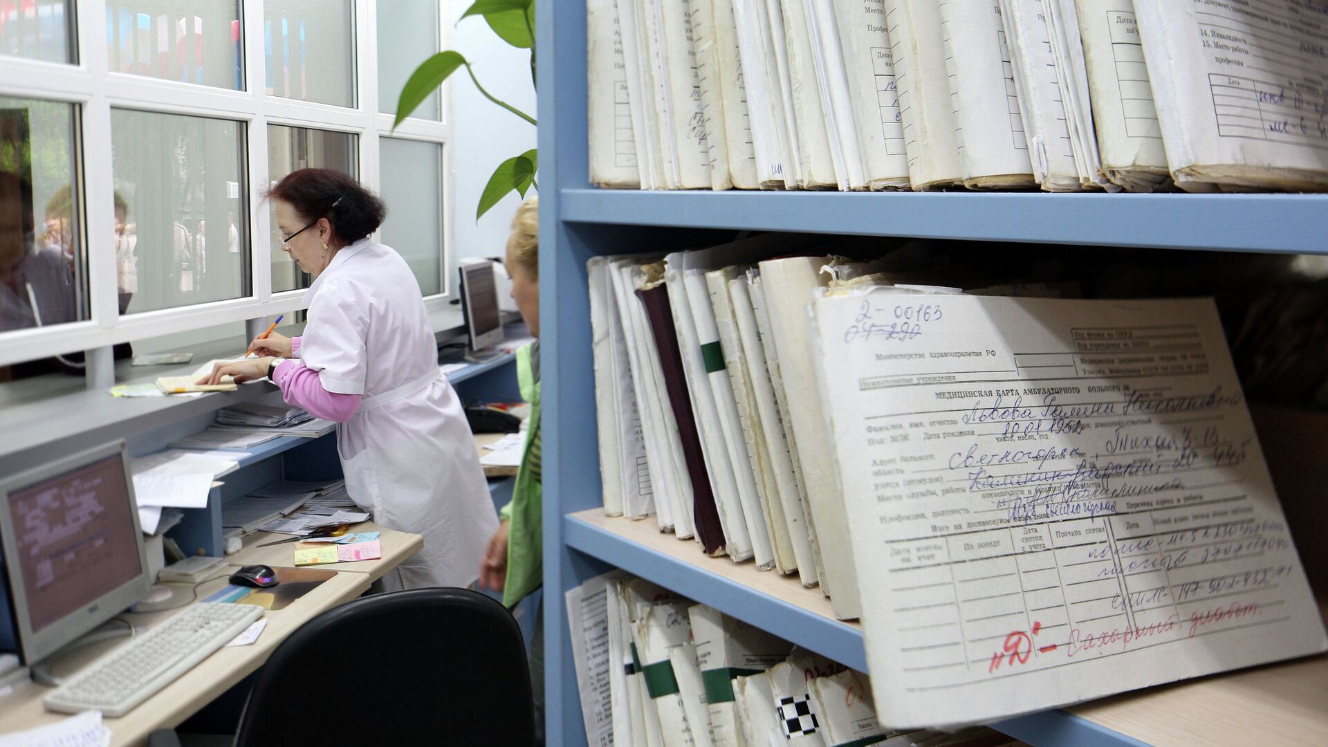 Медицинский работник выдает медицинскую карту пациенту в регистратуре поликлиники Медицинский работник выдает медицинскую карту пациенту в регистратуре поликлиники - РИА Новости, 1920, 02.06.2026