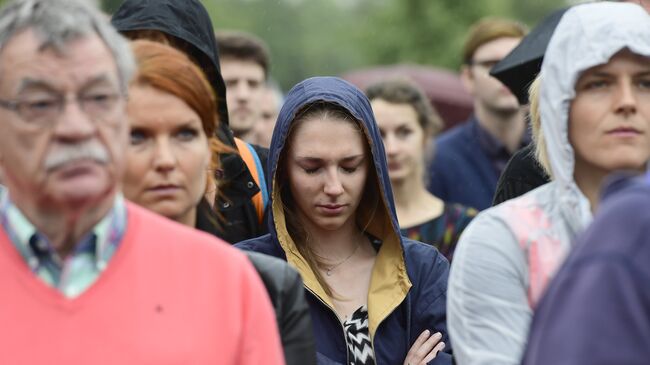 Люди почитают память жертв терракта в Ницце минутой молчания перед посольством Франции в Берлине. 15 июля 2016 года