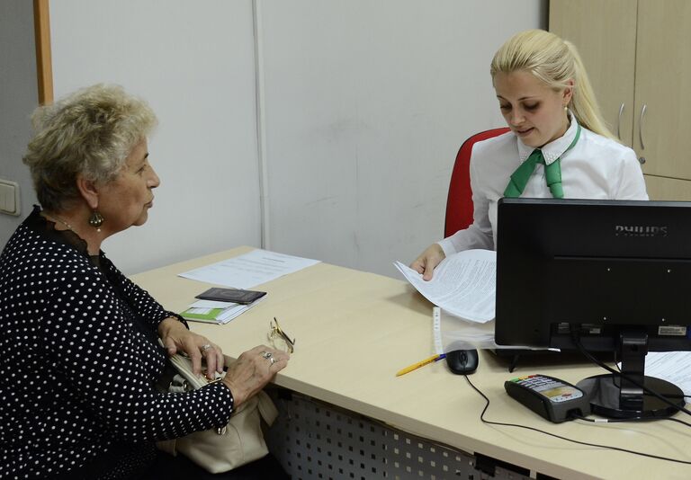 Женщина оплачивает коммунальные платежи в Российском национальном коммерческом банке в Крыму