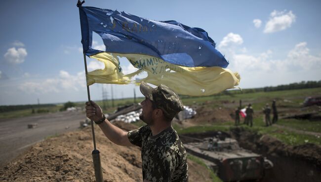 Украинский военный устанавливает флаг Украины в Марьинке недалеко от Донецка