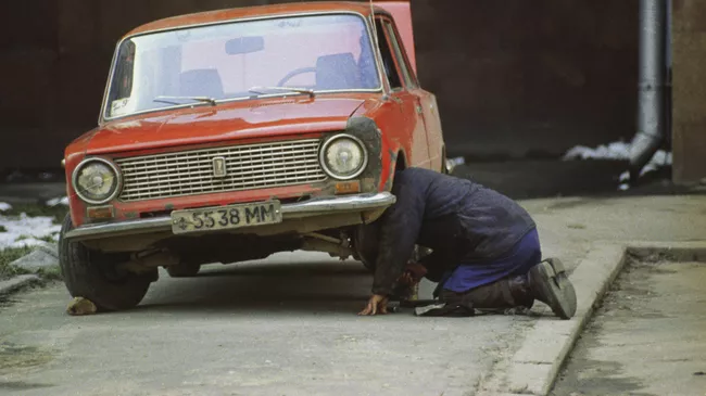 Мужчина ремонтирует старый автомобиль