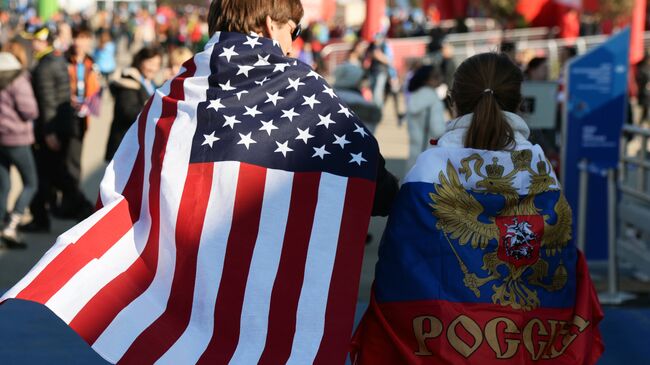 Молодые люди в национальных флагах США и России