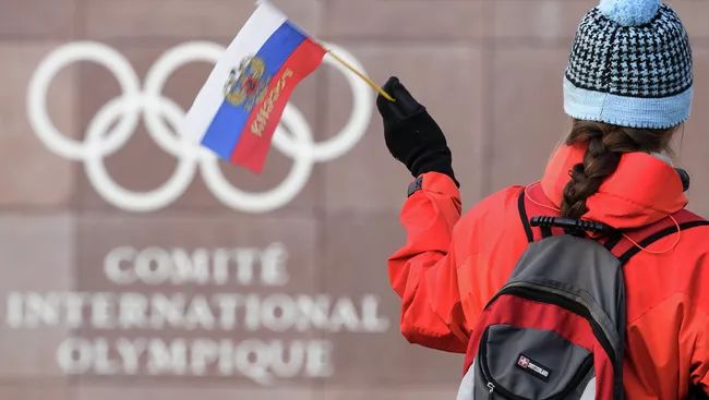 Российский флаг на фоне логотипа Международного олимпийского комитета (МОК)
