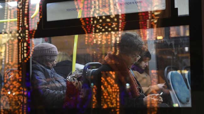 Пассажиры в салоне автобуса, проезжающего мимо Театральной площади в Москве