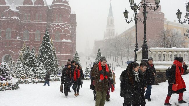 Прохожие во время снегопада на Манежной площади в Москве. Архивное фото