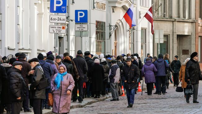 Люди стоят в очереди в российский консульский отдел в Риге, чтобы проголосовать на выборах президента РФ