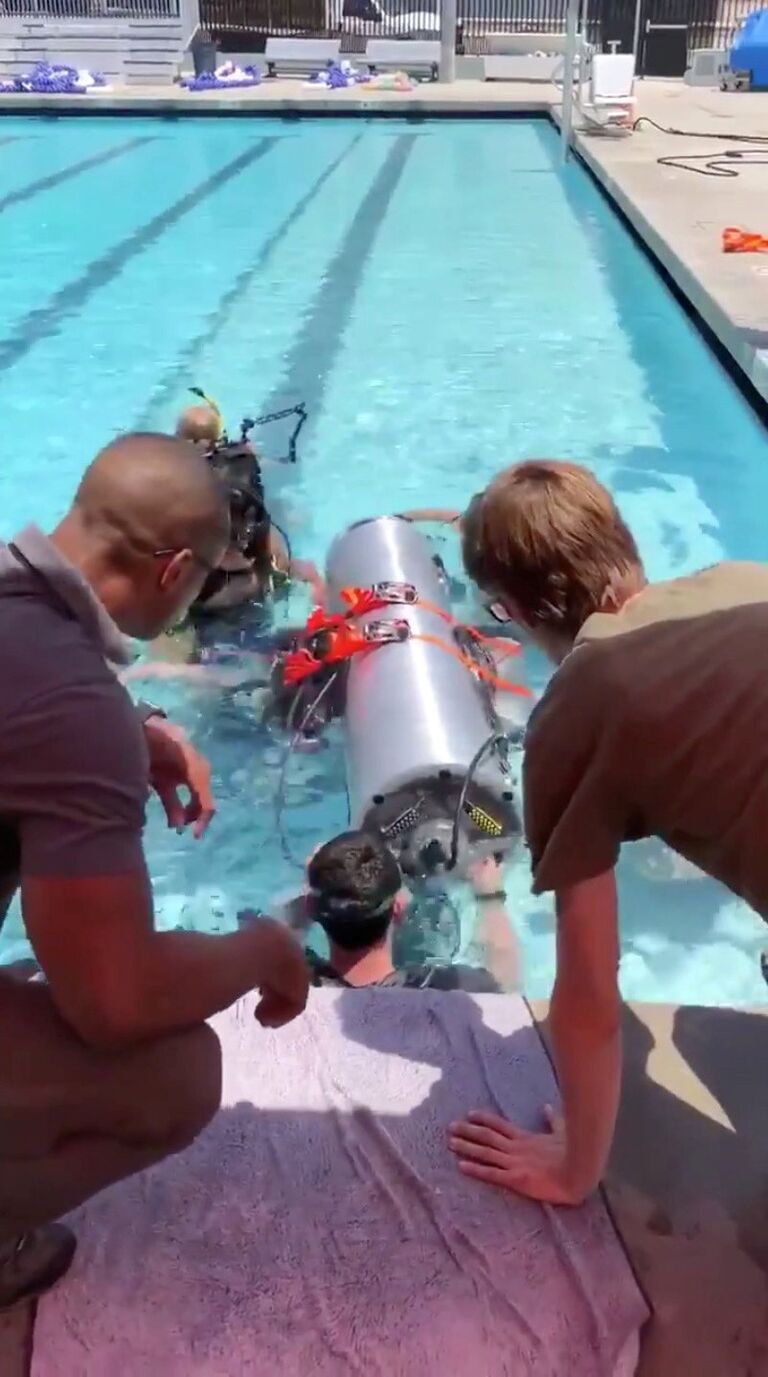 Устройство, созданное компаниями SpaceX и The Boring, принадлежащими Элону Маску, которое должно помочь спасти оставшихся членов футбольной команды из в затопленной пещеры, проходит испытания в бассейне в Лос-Анджелесе, Калифорния, США