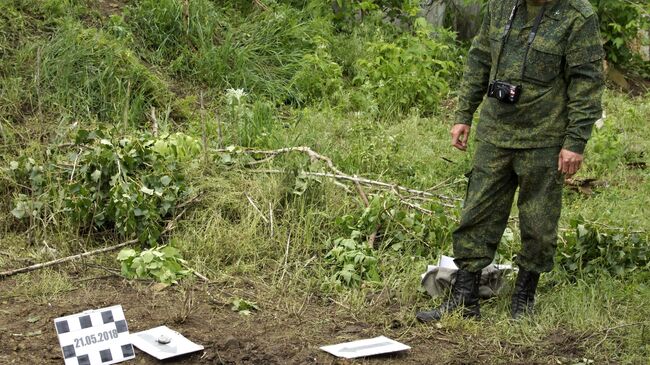 Военнослужащий ЛНР на месте попадания снаряда, выпущенного артиллерией ВСУ по поселку Калиново Луганской области. 20 мая 2018 