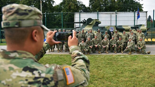 Военнослужащие армии США фотографируются у украинского бронетранспортёра БТР-3 на открытии многонациональных учений Rapid Trident-2018 на Яворовском полигоне во Львовской области