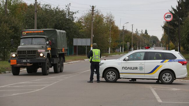 Сотрудники полиции Украины останавливают автомобили на дороге в Черниговской области после взрыва на военном складе. 9 октября 2018