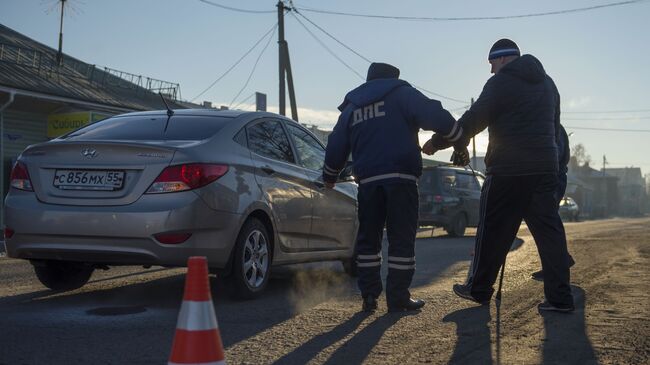 Сотрудник дорожно-патрульной службы ГИБДД на месте дорожно-транспортного происшествия 