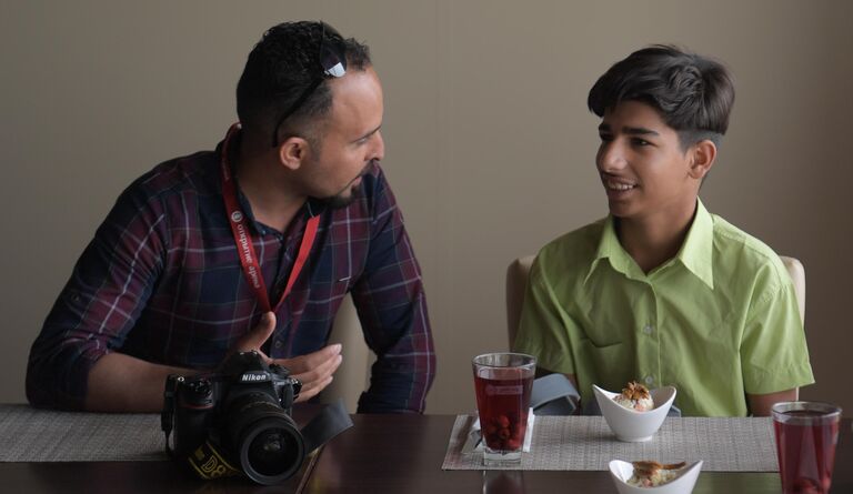 Герой снимка Желание жить, завоевавшего золото на Международном конкурсе фотожурналистики имени Андрея Стенина, иракский мальчик Касим Алькадим (справа) и фотограф Тайсир Махди во время посещения стадиона Открытие Арена в Москве.