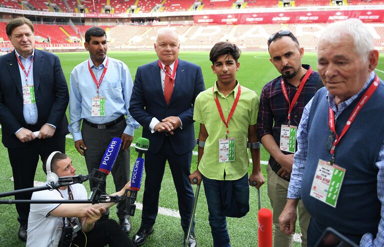 Президент Научно-исследовательского института неотложной детской хирургии и травматологии Леонид Рошаль (справа налево), фотограф Тайсир Махди, иракский мальчик Касим Алькадим, генеральный директор МИА Россия сегодня Дмитрий Киселев  и директор Института хирургии имени Вишневского Амиран Ревишвили во время посещения стадиона Открытие Арена в Москве.