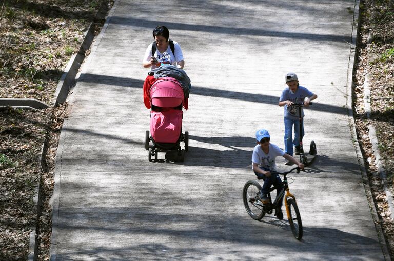 Женщина гуляет с детьми в парке