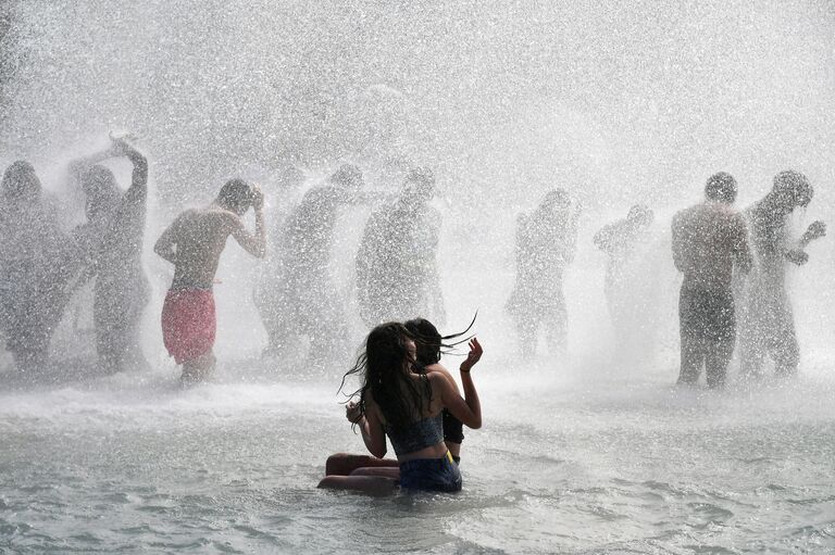 Горожане купаются в фонтане в садах Трокадеро в Париже. 27 июня 2019