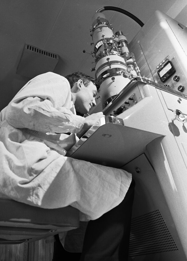 Научный сотрудник Института полиомелита и энцефалита АМН СССР изучает под электронным микроскопом вирусы бешенства Научный сотрудник Института полиомелита и энцефалита АМН СССР изучает под электронным микроскопом вирусы бешенства