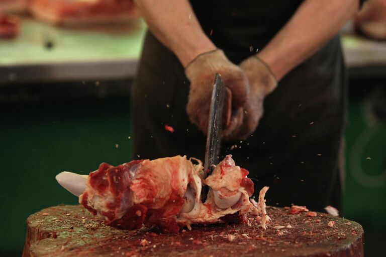 Продавец разделывает мясо
