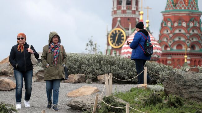 Жители Москвы, одетые в теплые осенние куртки, в парке Зарядье