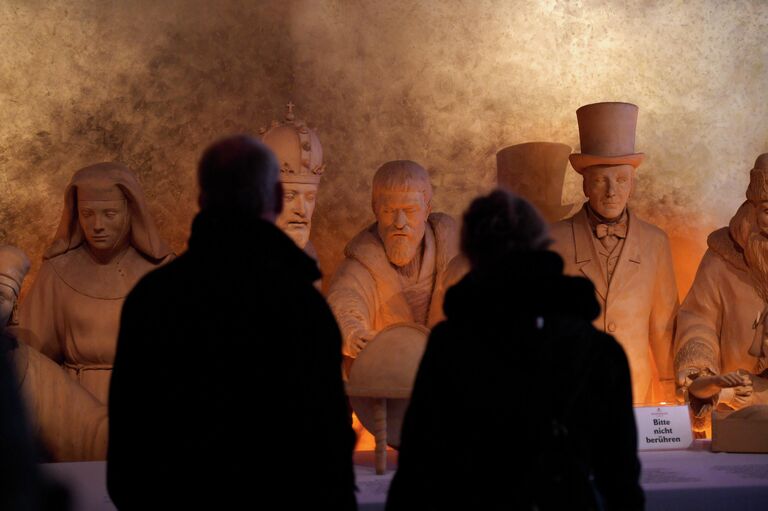 Посетители перед статуями, изготовленными из марципана, во флагманском магазин традиционной кондитерской фабрики Йоханна-Георга Нидереггера в Любеке, Германия
