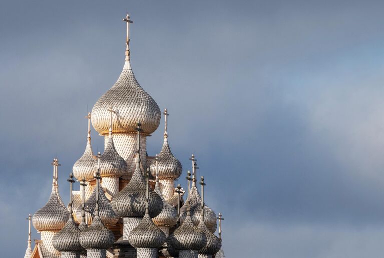 Купола, покрытые новыми осиновыми лемехами, Преображенской церкви XVIII века, входящей в состав архитектурного ансамбля Государственного историко-архитектурного музея-заповедника Кижи, на острове Кижи Онежского озера в Карелии