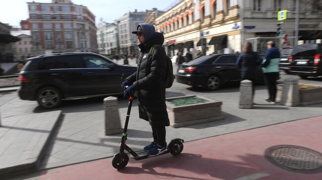 Мужчина едет на электросамокате