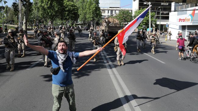 Протестующий во время акции протеста в Сантьяго