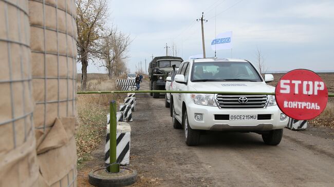 Автомобили специальной мониторинговой миссии ОБСЕ в селе Петровское в Донецкой области, где должен состояться отвод сил бойцов подразделений  ДНР