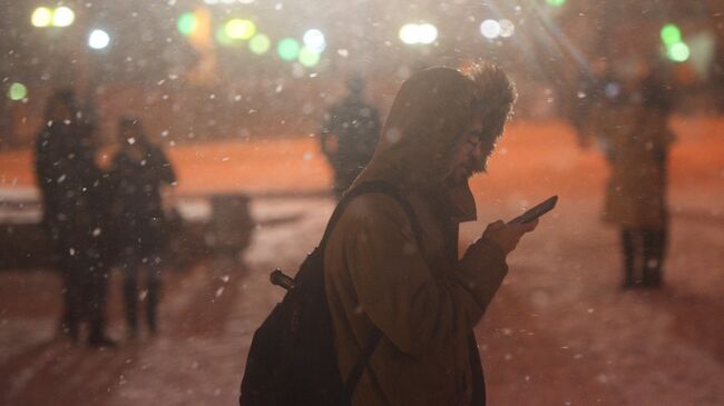 Прохожие во время снегопада в Москве