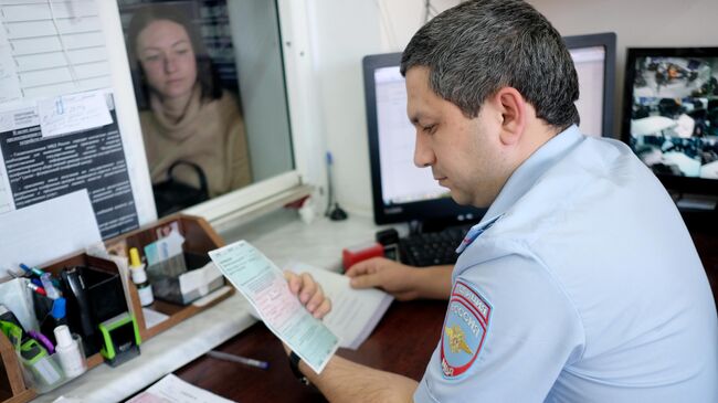 Сотрудник ГИБДД принимает документы на сдачу экзамена