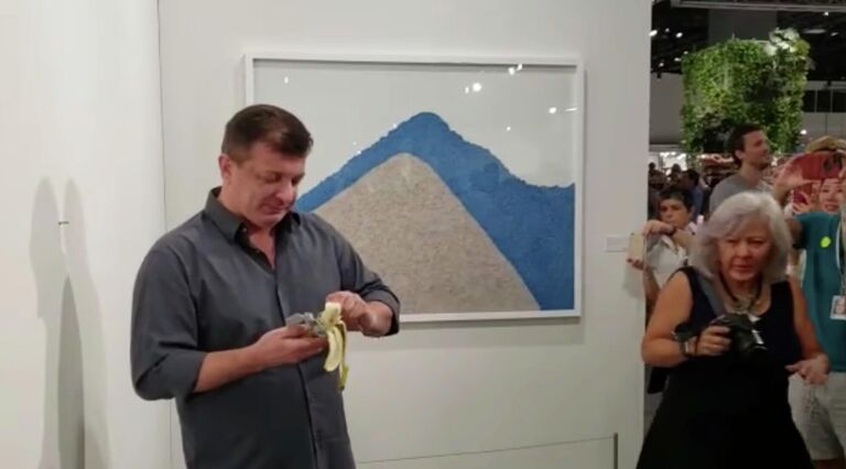 Художник Дэвид Датуна ест работу Маурицио Каттелана на выставке Арт-Базель