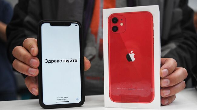 Смартфон компании Apple в руках покупателя. Архивное фото