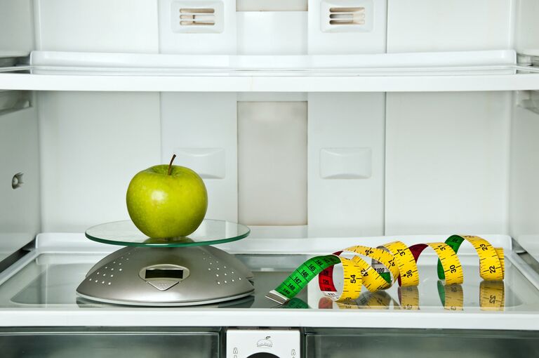 Яблоко и сантиметр в холодильнике